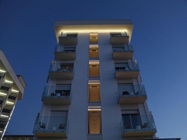 Modern building with balconies and night lights.